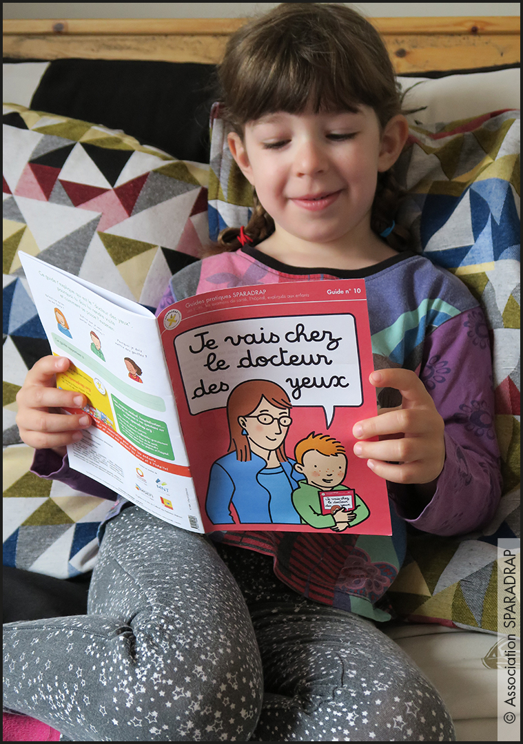 photo d'un enfant qui lit le guide "Je vais chez le docteur des yeux"