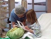Un médecin regarde un livre avec une petite fille hospitalisée