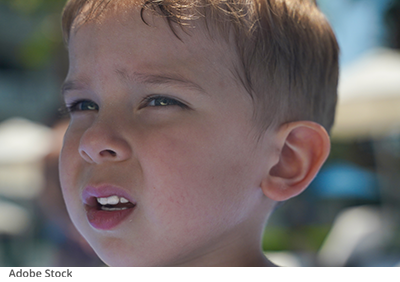 Enfant avec les yeux plissés