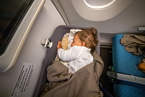 bébé endormi dans une nacelle lors d'un voyage en avion