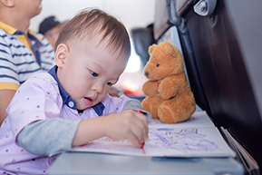 enfant qui dessine lors d'un voyage en avion