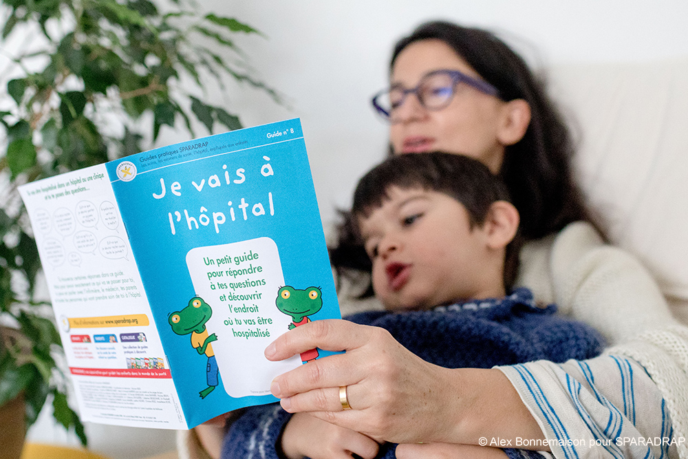 Une maman lit le guide "Je vais à l'hôpital" à son flis