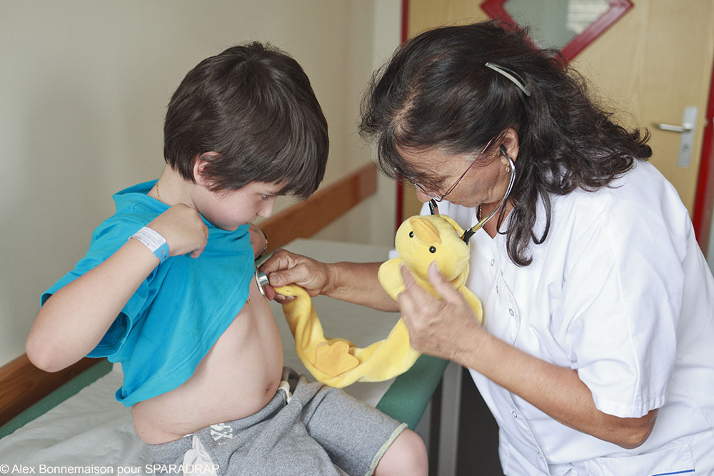 Une médecin osculte un petit garçon