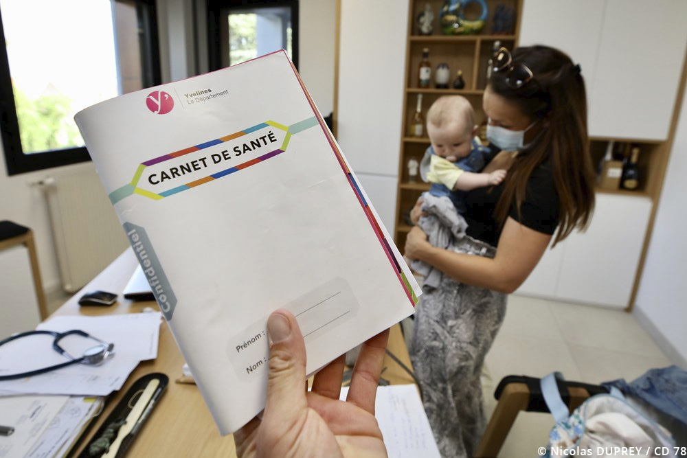 Un carnet de santé tendu lors d'une consultation