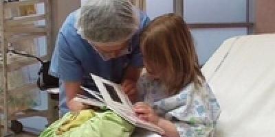 Un médecin regarde un livre avec une petite fille hospitalisée