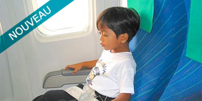 En fant assis sur un siège dans un avion