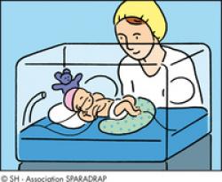 Un bébé prématuré couché dans une couveuse avec sa maman à ses côtés